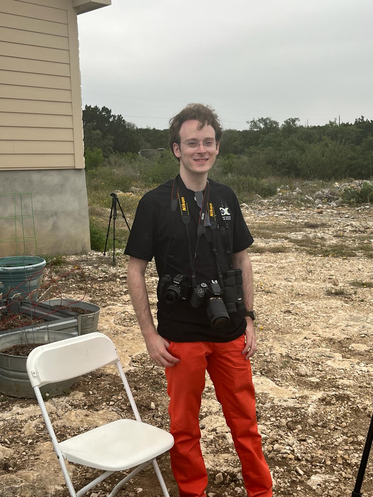 Allen standing at the 2024 eclipse site in Sabinal, Texas, with two cameras around his neck.